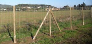 Cómo levantar una valla forestal con postes de madera y malla metálica alrededor de tu terreno
